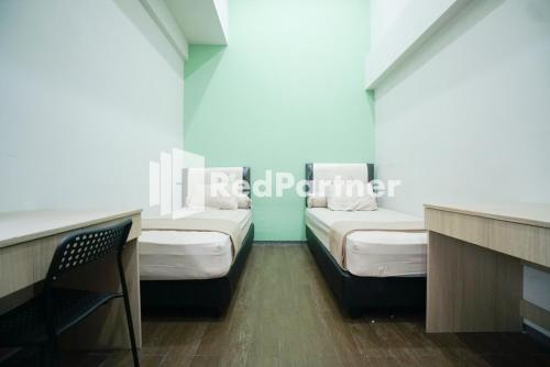 雅加达Toba Mansion Syariah near Benhil RedPartner的一间设有两张床和椅子的房间