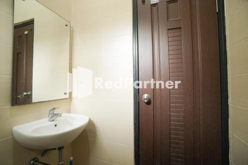 雅加达Toba Mansion Syariah near Benhil RedPartner的一间带水槽、镜子和门的浴室