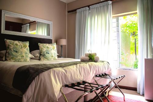 克龙斯塔德Kroon Manor的一间卧室配有一张带镜子的床和窗户