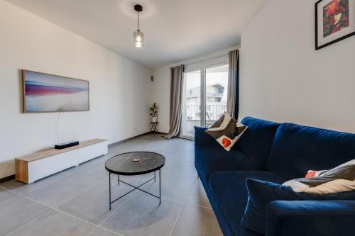 安锡Le Paradis - Beautiful T2 ideally located with garage的客厅配有蓝色的沙发和桌子