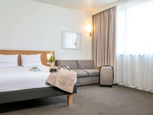 卡尔达诺阿尔坎波诺富特米兰马尔彭萨机场酒店的酒店客房,配有床和沙发