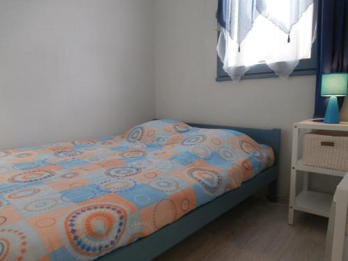 塞尼奥斯Appartement Seignosse, 2 pièces, 4 personnes - FR-1-239-460的小卧室配有带床罩和窗户的床