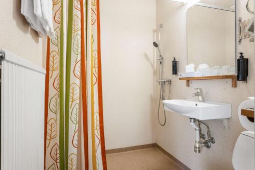 孙讷Hotell Frykenstrand; Sure Hotel Collection by Best Western的浴室配有淋浴帘和盥洗盆。