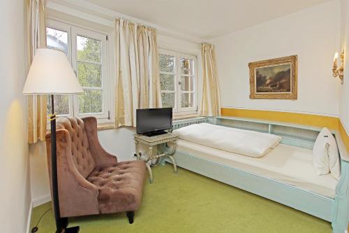 巴特维塞雷克斯酒店的一间卧室配有一张床、一把椅子和电视