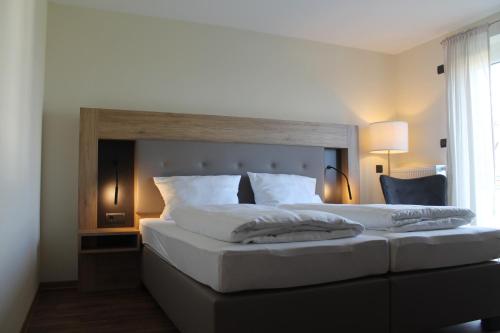 迈宁根Träbeser Bauernstube的一间卧室配有一张大床和木制床头板