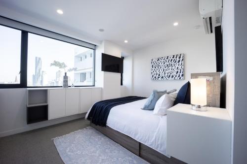 布里斯班Spring Hill - beautiful apartment的白色的卧室设有床和大窗户
