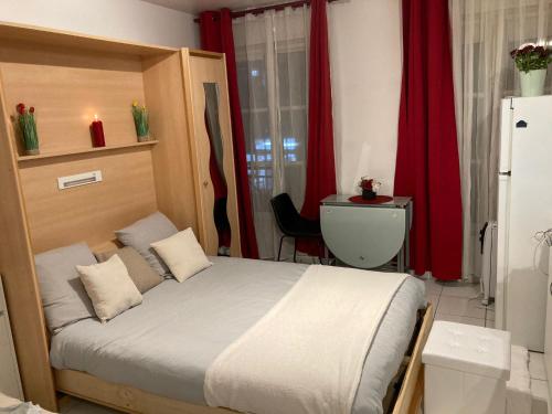 巴黎Studio calme et éclairé proche de Nation C的一间卧室配有床和红色窗帘