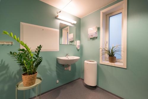 特隆赫姆Rumi Hostel的绿色浴室设有水槽和镜子