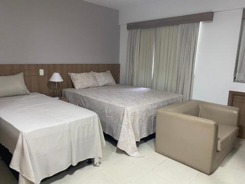 巴西利亚Flat hotel saint moritz的酒店客房,配有两张床和椅子