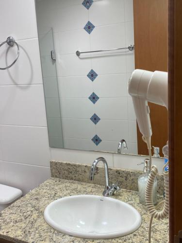 巴西利亚Flat hotel saint moritz的浴室的柜台设有水槽和镜子