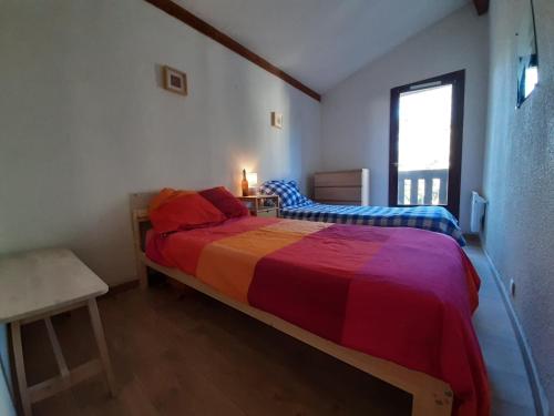 塞尼奥斯Maison Seignosse, 3 pièces, 4 personnes - FR-1-239-385的一间卧室配有一张大床和彩色床罩