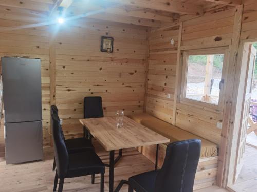 Kuće sa bazenom Višegrad Drina的小木屋内的用餐室,配有桌椅