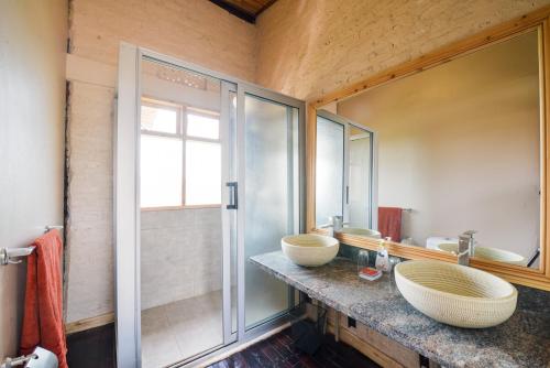 波特尔堡The Coffee Lodge at Clarke Farm的一间带两个盥洗盆和淋浴的浴室