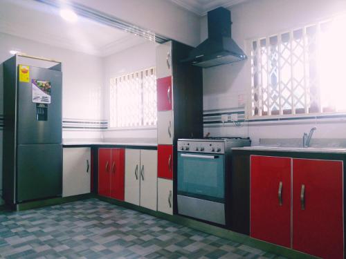 BortianorCity Stay lodging center的厨房配有红色和白色的橱柜和炉灶。