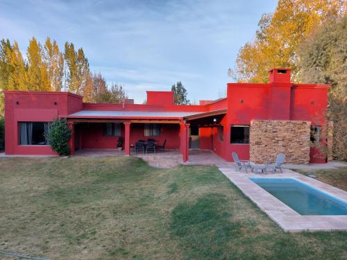 图努扬Puerta 1910的一座红色的房子,前面有一个游泳池