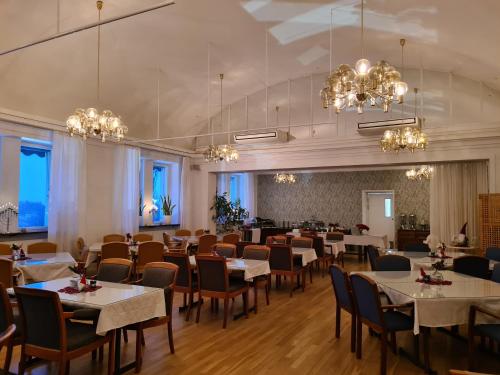 皮特奥福伦纳赛特会议酒店 的用餐室配有桌椅和吊灯。