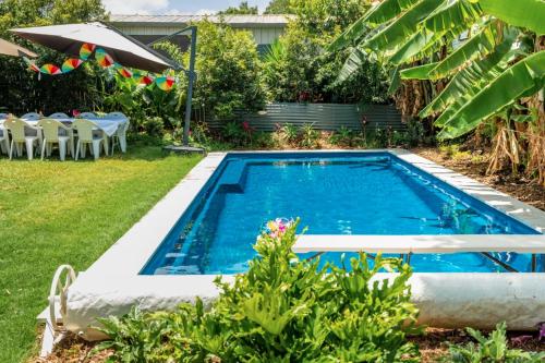 布里斯班OXLEY Private Heated Mineral Pool & Private Home的后院的游泳池,配有桌椅