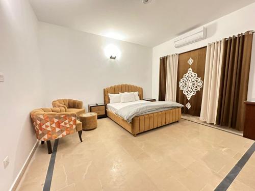 拉瓦尔品第Islamabad Travelodge Guest House的一间卧室配有一张床和一把椅子