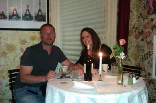 汉尼拔花园房住宿加早餐旅馆的坐在桌子旁的男人和女人,喝一瓶葡萄酒