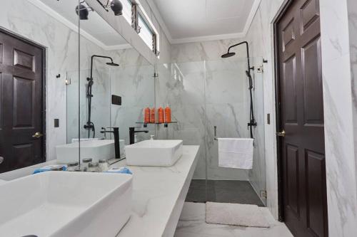 Nuevo CuscatlánNew in the heart of the city 5 min to US Embassy的白色的浴室设有2个盥洗盆和1个浴缸。