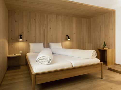 瓦尔斯阿尔皮纳酒店的木墙客房的一张床位