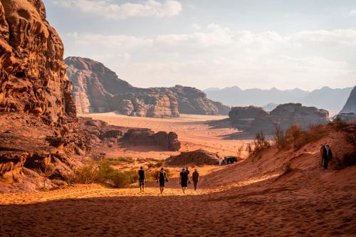 瓦迪拉姆Wadi rum secrets camp的一群人沿着沙漠的土路走