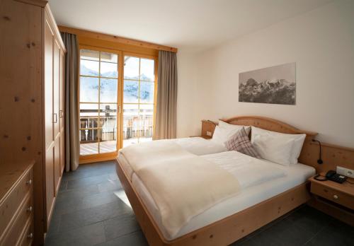 库哈台库苔阿尔卑斯旅馆的一间卧室设有一张大床和一个大窗户