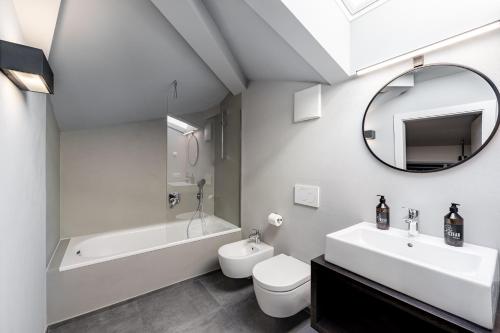博尔扎诺Stay COOPER l CITY LOFT的浴室配有盥洗池、卫生间、浴缸和镜子