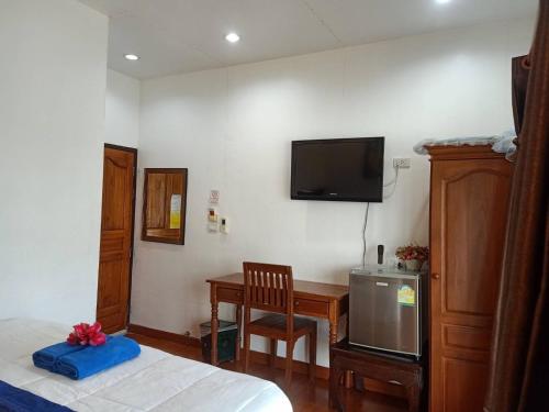 北碧塔拉拉夫特酒店的一间卧室配有一张床和一张书桌,墙上配有电视。