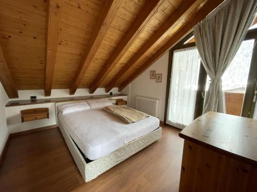 GiustinoCondominio Gaiolin的一间卧室设有一张床和木制天花板