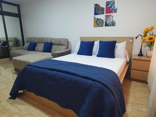 拉克鲁斯Marina Beach的一间卧室配有一张大床和一张沙发