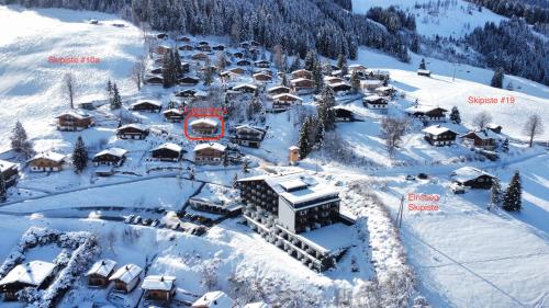 玛丽亚阿尔姆Ski-in & Ski-out out Chalet Maria with amazing mountain view的雪地中度假村的空中景观
