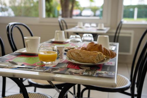 马尔萨克Fasthôtel Périgueux的一张桌子,上面放着一盘面包和橙汁