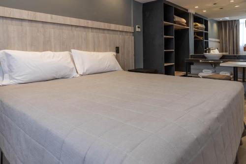 门多萨HOTEL M的卧室内的一张带白色枕头的大床