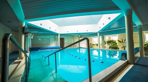 斯文托伊厄纳杰帝卡斯健康与康体中心度假村的一座拥有蓝色天花板的室内游泳池