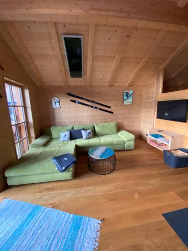 拉赫塔尔Skihütte的小屋内带绿色沙发的客厅