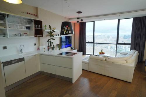 安卡拉Lux Residance 40th floor, sound system, 65 inch TV的带窗户的客房内设有带水槽和沙发的厨房