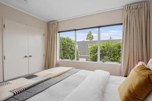 奥克兰Gorgeous 2BR Central Akl Retreat - WI-FI - Netflix的一间卧室设有一张床和一个大窗户
