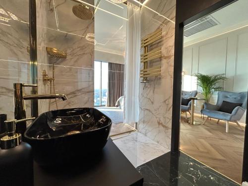什切青Hanza Tower HOME4U的一间位于客房内的带黑色浴缸的浴室