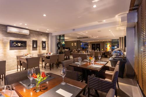 弗洛里亚诺波利斯法亚尔尊贵套房酒店的配有木桌和桌椅的餐厅