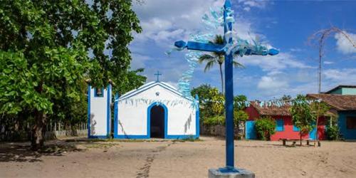 卡拉伊瓦Casa da Lua no centro da Vila de Caraíva ao lado da Igreja de Caraíva的一个小教堂前的蓝色十字架