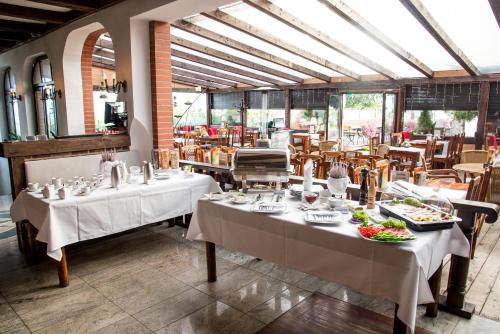 乌斯特卡COLUMBUS Ustka - Marynarki Polskiej 2的餐厅设有两张桌子,上面放着食物盘