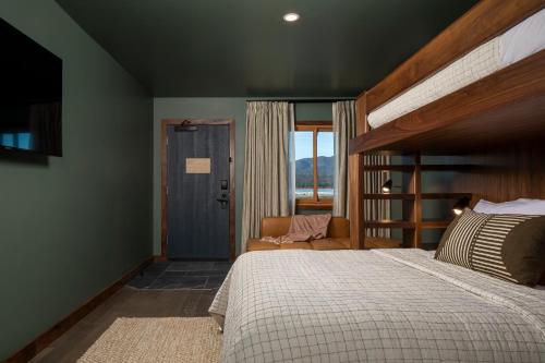 大熊湖Hotel Marina Riviera的卧室配有床、椅子和窗户。