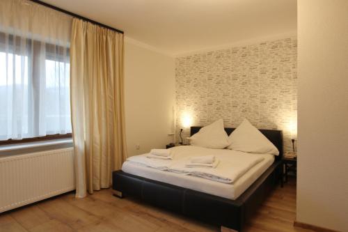文盖尔斯卡－古尔卡Willa na Plażowej的一间卧室配有一张带白色床单的床和一扇窗户。
