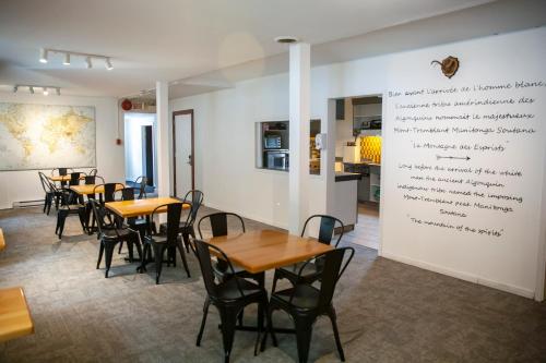 蒙特朗布朗Auberge Manitonga的一间餐厅,配有桌椅和一面墙上的书写