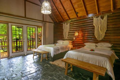 圣玛丽戴尔奥罗Santa María Resort的配有木墙和窗户的客房内的两张床