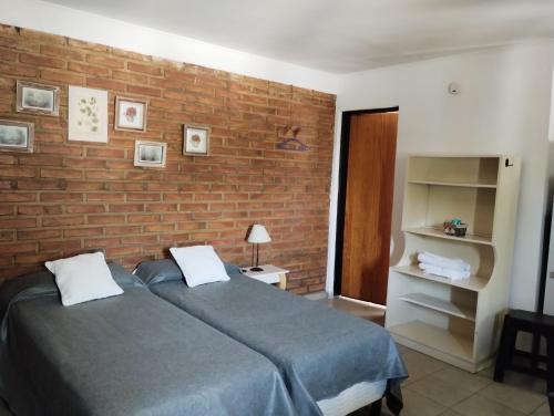 圣罗莎El Poblador的一间卧室设有两张床和砖墙