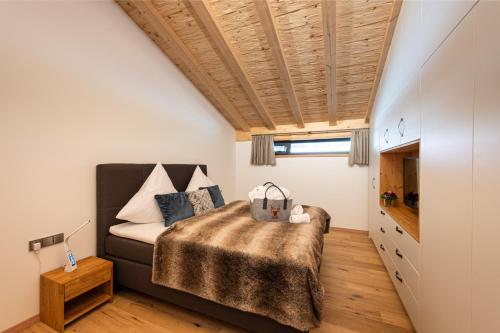 奥伯斯特多夫Alpine Lifestyle Lodge的一间卧室设有一张床和木制天花板