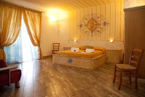 莫尔恰诺迪莱乌卡Antico Borgo Marchese的一间卧室配有一张大床和椅子