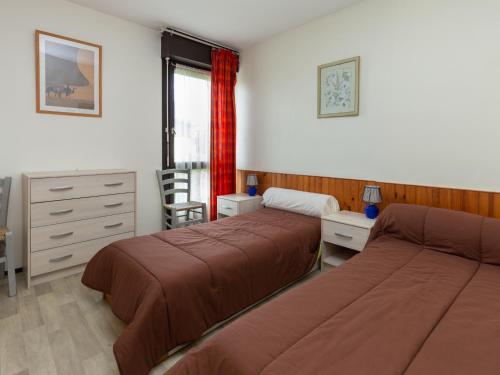 塞尼奥斯Appartement Seignosse, 3 pièces, 6 personnes - FR-1-239-401的一间卧室配有两张床、一张桌子和一把椅子